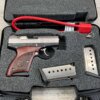 Gun replica with wooden grip, silver slide, and empty magazines in foam-padded case, themed for collectibles or cosplay, not actual firearm.